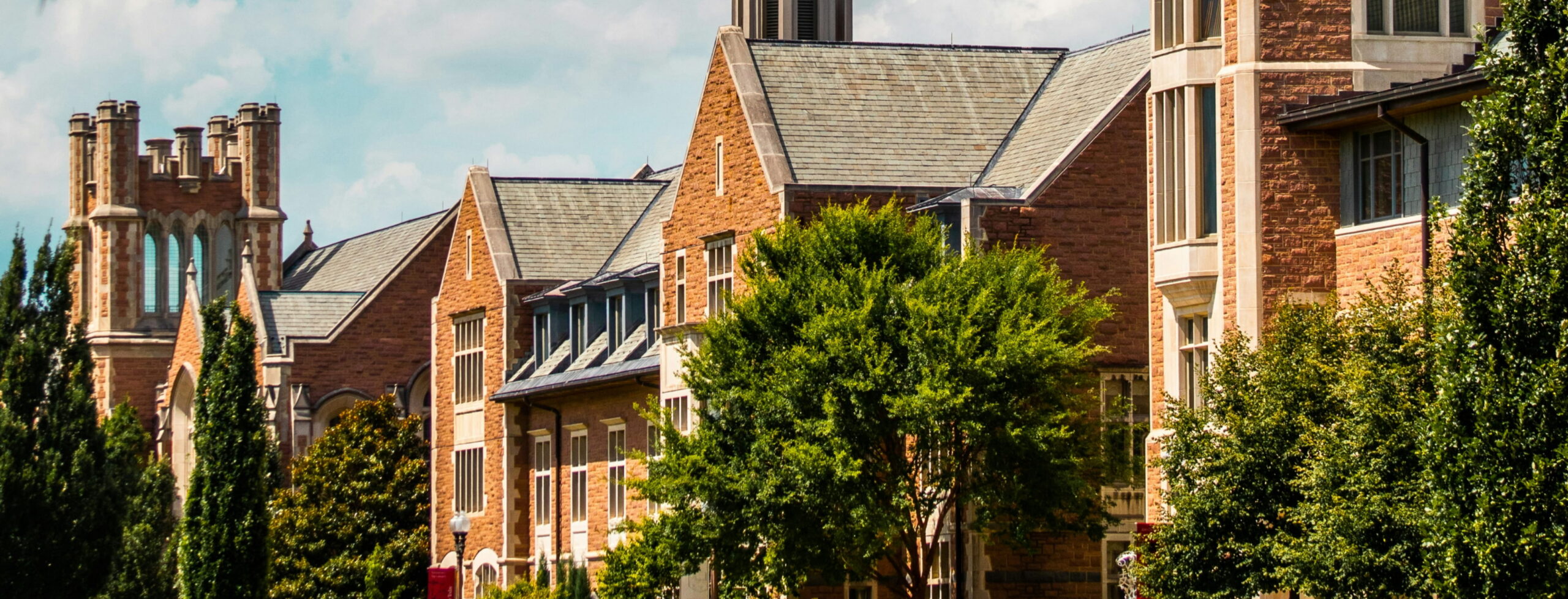 Collegiate Gothic style stone buildings with gabled roofs on a university campus